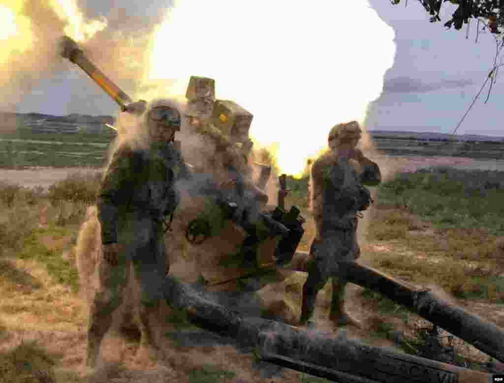 Spanish soldiers fire a howitzer as part of maneuvers with other units during NATO exercises. (epa/Javier Cebollada)