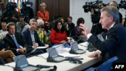 Gazprom CEO Aleksei Miller (left) listens as EU Energy Commissioner Guenther Oettinger (right) speaks during a press conference after the talks in Berlin on energy security.