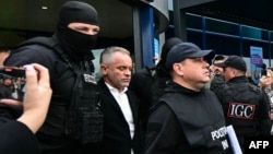 Moldovan oligarch Vladimir Plahotniuc (center) exits Chisinau International Airport under police escort on September 25 after his extradition from Greece. 
