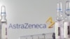  Ampule vakcine ispred znaka kompanije AstraZeneca, ilustrativna fotografija