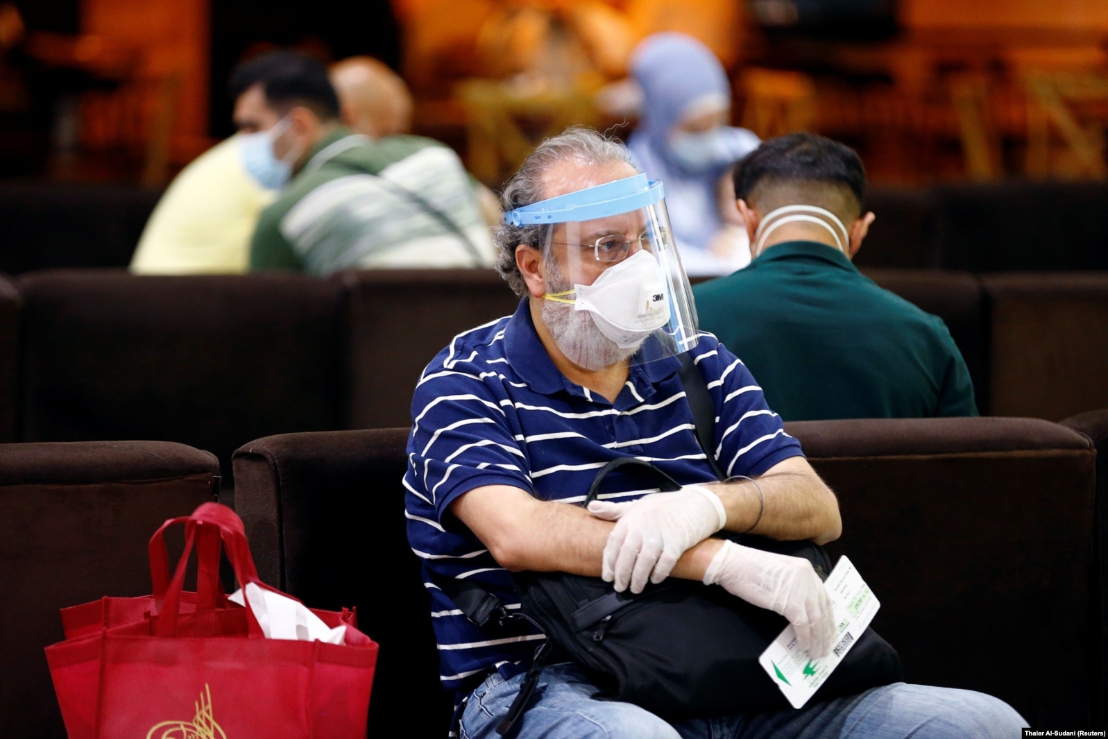 Një pasagjer duke pritur fluturimin në ambiente të aeroportit.