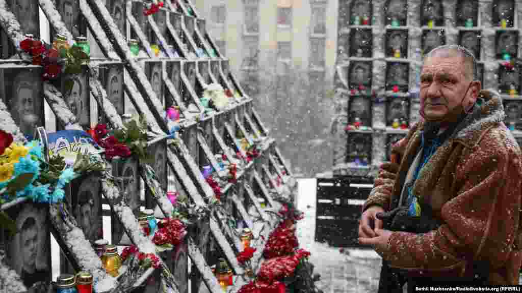 Мужчина зажигает свечу в Киеве у памятника &laquo;Небесной сотне&raquo; &mdash;&nbsp;104 украинцам, убитым силами безопасности во время антиправительственных акций протеста в 2014 году. 18 февраля