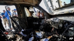 Njerëzit duke e shikuar veturën e Kuzhinës Qendrore Botërore, e cila u shkatërrua nga sulme izraelit me dronë në Rripin e Gazës, 2 prill 2024. 