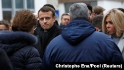 Emanuel Makron, francuski predsednik, i njegova supruga Brižit razgovaraju sa porodicama ubijenih pred nekadašanjim prostorijama nedeljnika Šarli Ebdo
