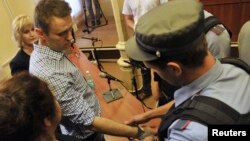 A policeman puts handcuffs on opposition leader Aleksei Navalny inside the courtroom in Kirov on July 18.