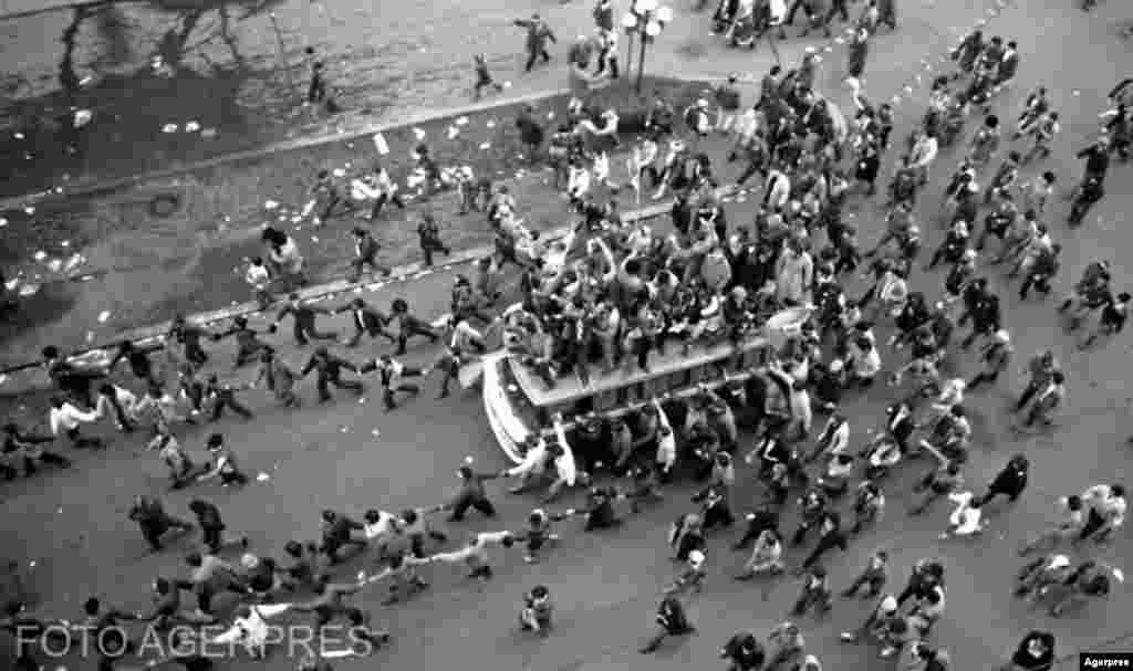 București, 22 sau 23 decembrie 1989. Momentul fugii dictatorului este povestit de cei care l-au trăit pe străzi cu multă emoție. Bucuria libertății a fost imensă. Unii spun că aveau sentimentul că pluteau, alții nu își puteau stăpâni lacrimile. Speranța era pretudindeni. Chiar și pe acoperișul unui autobuz, după cum se vede în imaginea de mai jos.&nbsp;