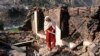 A Kashmiri woman stands amid the debris of her home that was reportedly destroyed by cross-border shelling from Indian troops, in the Neelum Valley, situated at the de facto border in Pakistani Kashmir on December 23. 