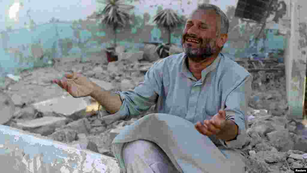 A man cries in front of houses destroyed during a Syrian Air Force air strike in Azzaz. (Reuters/Goran Tomasevic)