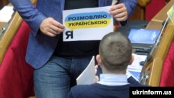 Народний депутат Віктор Кривенко у Верховній Раді в День української писемності та мови демонструє колезі листівку (архівне фото)