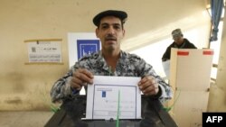 An Iraqi officer casts his vote in central Baghdad