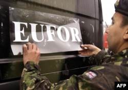 Britanski vojnik SFOR-a lijepi novu naljepnicu "EUFOR" na svoje vozilo u vojnoj bazi Ramići u blizini Banja Luke na sjeverozapadu BiH, 1. 12. 2004.