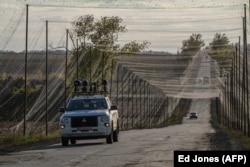 A vehicle fitted with signal jamming equipment drives along a road covered by anti-drone nets in eastern Ukraine on October 2.