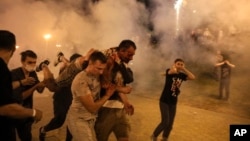 Protesters in Minsk carry a wounded man during clashes with police after Belarus's disputed presidential election in August 2020