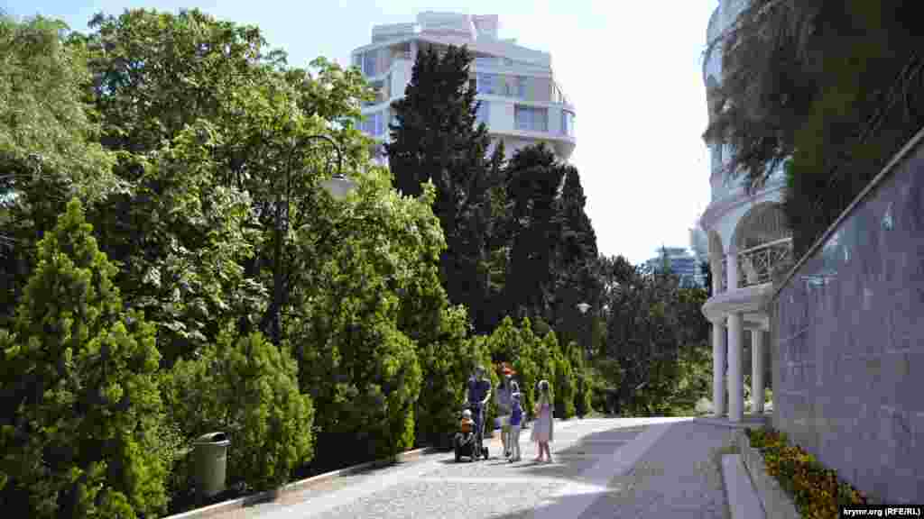 При входе в парк по главной аллее видно не только цветущие&nbsp;деревья и кустарники, но и возвышающиеся над ними здания из бетона и стекла