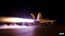 A US Navy handout photograph released on July 28 by US Central Command shows a Super Hornet fighter jet launching from the flight deck of the USS George HW Bush aircraft carrier, which is operating near the Persian Gulf. 