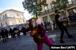 Një protestuese duke hedhur një gur gjatë protestës së 17 tetorit në Tiranë.