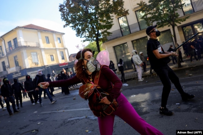 Një protestuese duke hedhur një gur gjatë protestës së 17 tetorit në Tiranë.