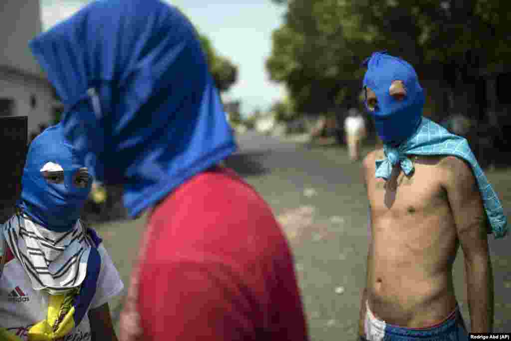 Masked antigovernment protesters gather a few blocks from the border bridge in Urena, Venezuela, on the border with Colombia, where Venezuelan soldiers blocked humanitarian aid from entering. (AP/Rodrigo Abd)