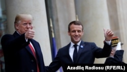 U.S. President Donald Trump and French President Emmanuel Macron gesture as they meet at Elysee presidential palace.