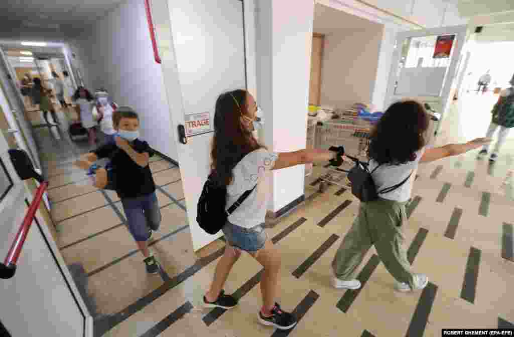 Deca jure hodnikom prema svojoj učionici nakon što su prošli medicinske provere prvog dana škole u Nacionalnoj muzičkoj školi Žorž Enesku u Bukureštu, Rumuniji 14. septembra.