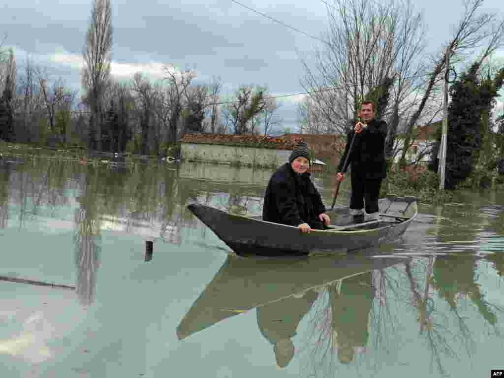 Montenegro -- People in a canoe paddle trough flooded streets in Bistrice, 06Dec2010 - MONTENEGRO, Bistrice : Montenegrins in a canoe paddle trough flooded streets in Bistrice, south of the capital Podgorica, on December 6, 2010. Flooding caused by rivers swollen by heavy rainfall continued to plague the Western Balkans with thousands evacuated in Bosnia, Serbia and Montenegro. AFP PHOTO / SAVO PRELEVIC 10POTW49 10poty