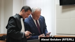 Igor Dodon discută cu avocatul său Petru Balan, înainte de ședința de judecată.