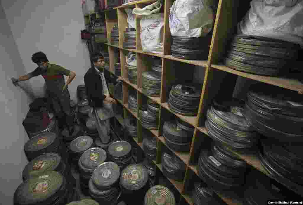 Workers stand among film cans inside a crowded storage room on May 3, 2012.Afghan cinemas have long been dilapidated and underfunded, the result of an industry suffering from conflict and financial despair.