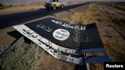 Yrakda "Yslam döwleti" ekstremistik toparyna degişli ýazgy köçäniň gyrasynda ýatyr. 2017 ý.