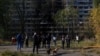 Residents gather in front of an apartment building that was damaged by a Russian missile strike in Kyiv on October 14.