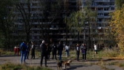 Residents gather in front of an apartment building that was damaged by a Russian missile strike in Kyiv on October 14.