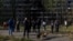 Residents gather in front of an apartment building that was damaged by a Russian missile strike in Kyiv on October 14.