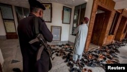 FILE: A soldier guards religious students attending a lesson at Darul Uloom Haqqania, an Islamic seminary and the alma mater of several Taliban leaders in Khyber Pakhtunkhwa Province, Pakistan.