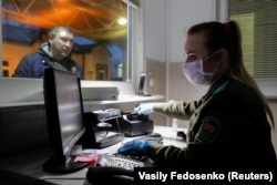 A Belarusian border guard wears a face mask and gloves to protect herself from the coronavirus early in the pandemic. Belarus closed off its borders to foreigners on November 1.
