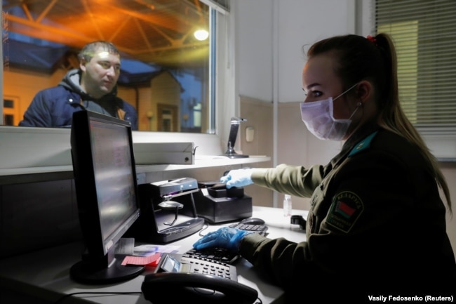 A Belarusian border guard wears a face mask and gloves to protect herself from the coronavirus early in the pandemic. Belarus would later close off its borders to foreigners.