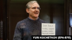 Paul Whelan holds up a sign denouncing the legal proceedings against him as he stands inside the defendant's cage before hearing the verdict of his espionage trial at the Moscow City Court on June 15. 