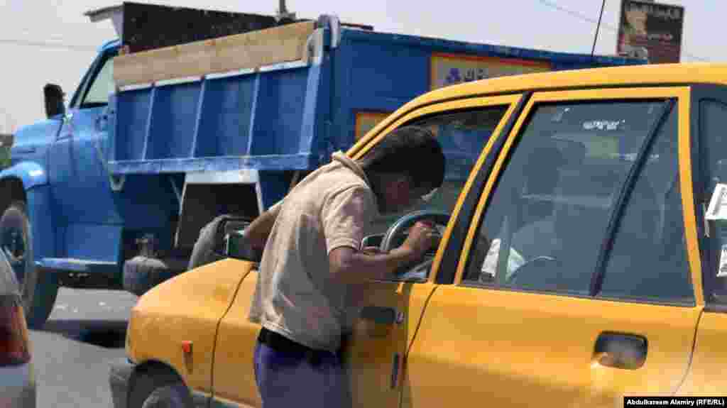 A young street vendor talks to a potential customer in Basra.