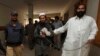 Pakistani Police escort a man through the halls of a court in Karachi.