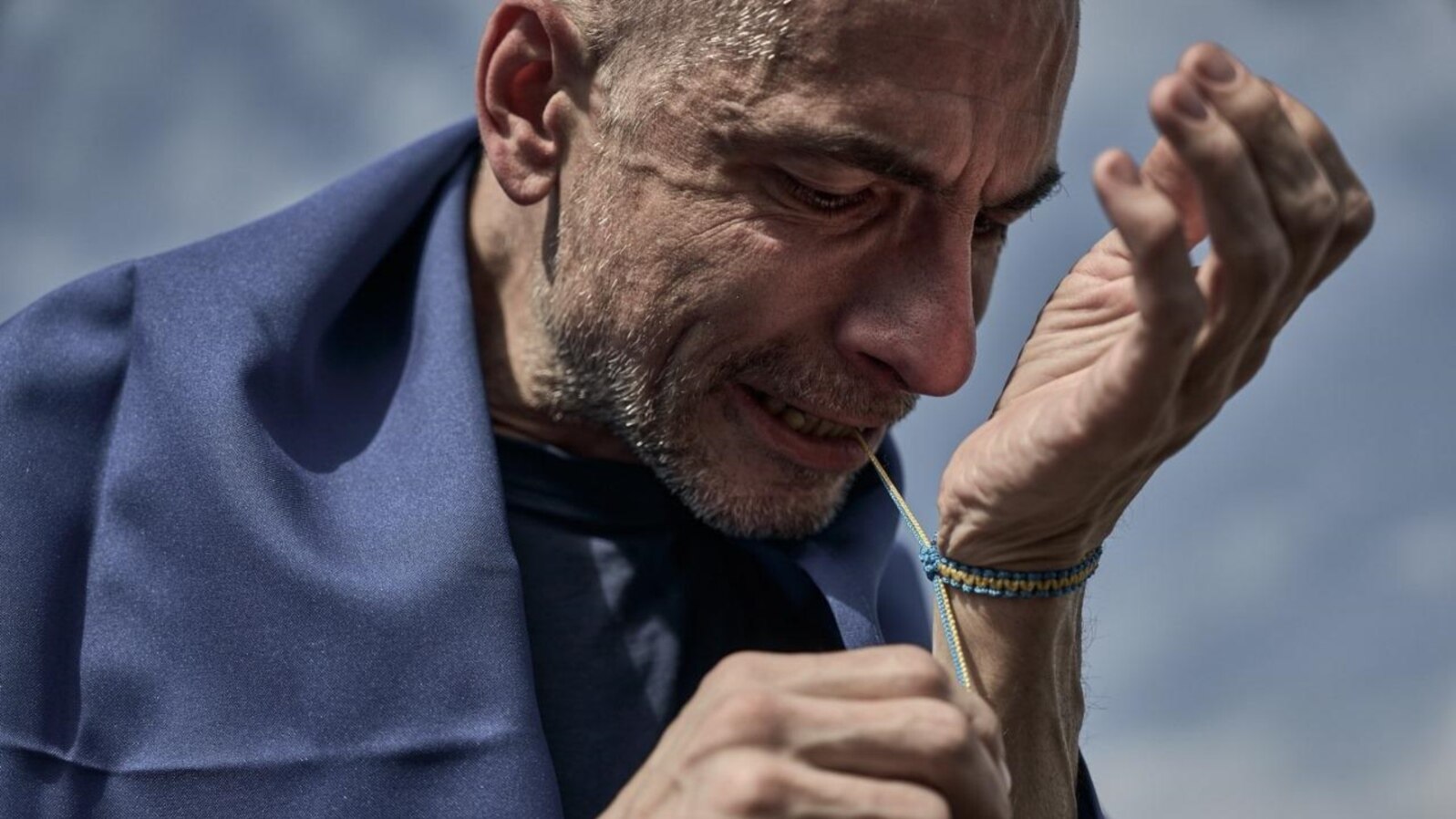 Ihor Titovski își leagă la mână o brățară în culorile Ucrainei, imediat după eliberarea sa din captivitate și întoarcerea în țară, în septembrie 2024. A fost capturat la Mariupol în mai 2022. 