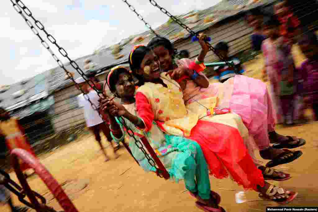 Rohingya refugee children ride on a swing ride in the Kutupalong refugee camp in Cox&rsquo;s Bazar, Bangladesh. (Reuters/Mohammad Ponir Hossain)