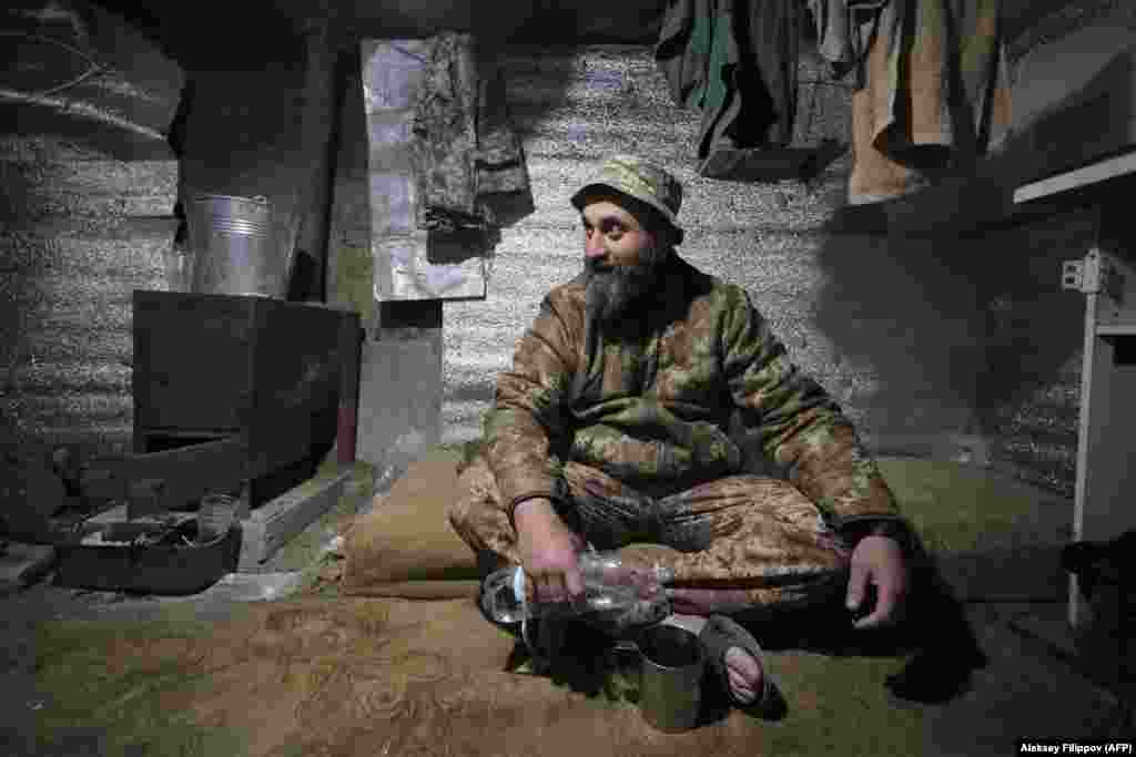 A Ukrainian serviceman rests in a dugout on the front line near Mariupol in eastern Ukraine. (AFP/Aleksei Filippov)