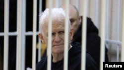 Nobel Peace Prize laureate Ales Byalyatski, who co-founded the Vyasna human rights group, sits inside a defendants' cage during a court hearing in Minsk in January 2023.