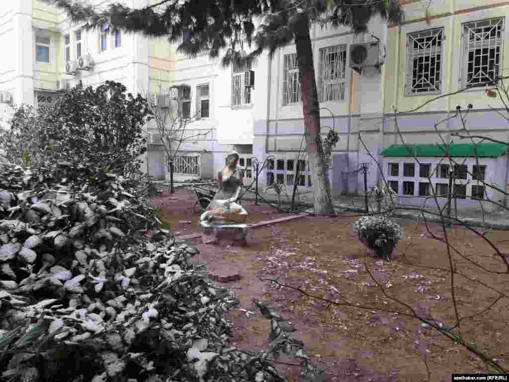 Aşgabatdaky köp gatly jaýlaryň biriniň arkasyndaky kiçi monument