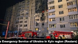 Firefighters work at the site of an apartment building damaged during a Russian drone strike in the town of Hlevakha, Kyiv region, Ukraine, on January 24.