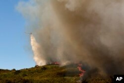 Një avion hedh ujë mbi zjarrin pranë fshatit Rebordondo, në Spanjën veriperëndimore, më 18 gusht 2025.