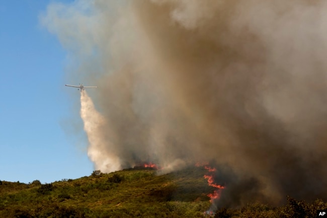 Një avion hedh ujë mbi zjarrin pranë fshatit Rebordondo, në Spanjën veriperëndimore, më 18 gusht 2025.