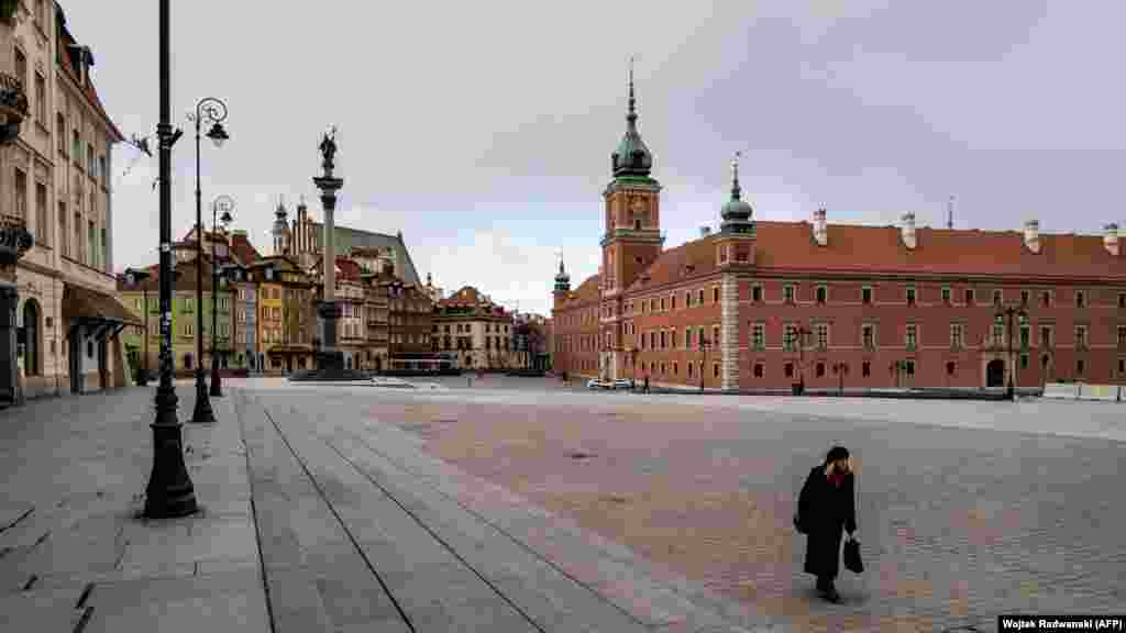 Poland - A woman walks on an empty square in the center of Warsaw, 14Mar2020