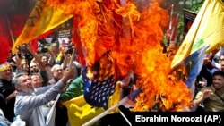 State organized demonstrators burn Israeli and U.S. flags to show their anger over the deaths of nearly 60 Palestinians along the Gaza border on Monday, during a protest outside the former U.S. embassy in Tehran, May 16, 2018. File photo