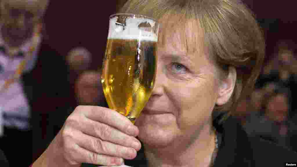 German Chancellor Angela Merkel toasts with a glass of beer during a Political Ash Wednesday meeting of the Christian Democratic Union (CDU) in Demmin on February 22. (REUTERS/Thomas Peter)