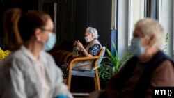 A Nógrád Megyei Kormányhivatal munkatársa egy lakóval beszélget a balassagyarmati idősek otthonában 2020. április 22-én. 