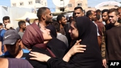 Palestinians react outside the al-Aqsa Martyrs hospital after an Israeli strike hit a school housing displaced people in Deir al-Balah in the central Gaza Strip on October 10.